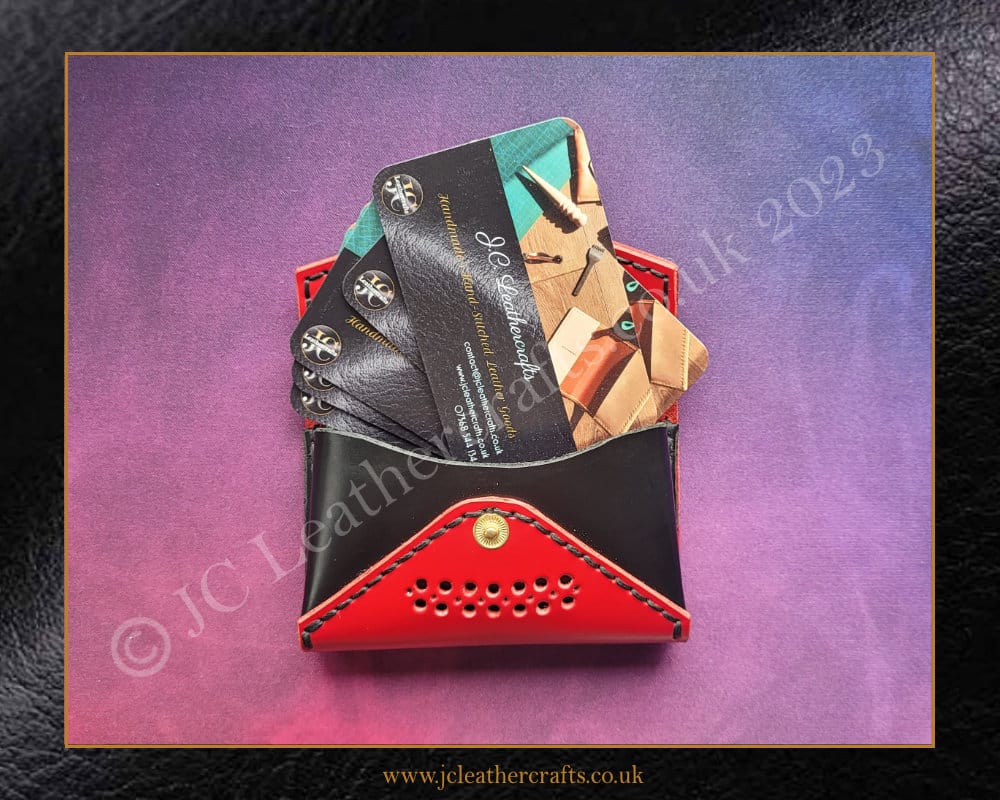 Red and black leather business card holder showing JC Leathercrafts business cards